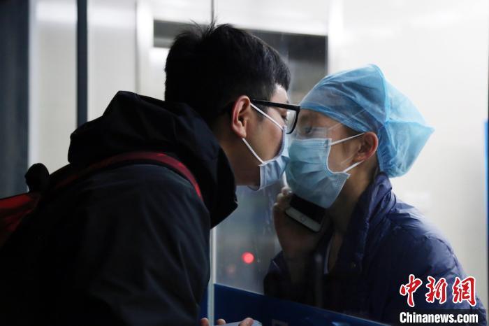 Nữ y tá hôn bạn trai qua tấm kính cách ly gây xúc động mạnh