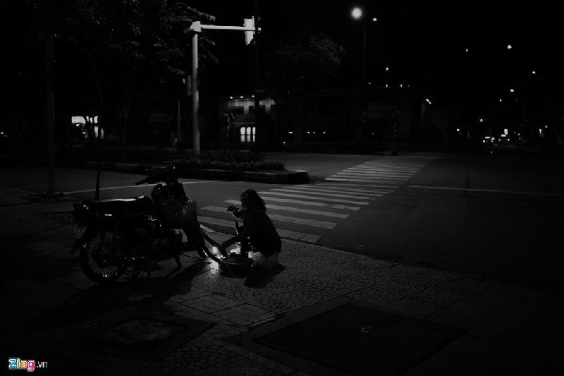 Tại góc đường Hàm Nghi - Nam Kỳ Khởi Nghĩa (TP HCM), những ai về khuya đi qua đều thấy một người phụ nữ cao tuổi cặm cụi vá xe mỗi đêm trong ánh đèn pin le lói.