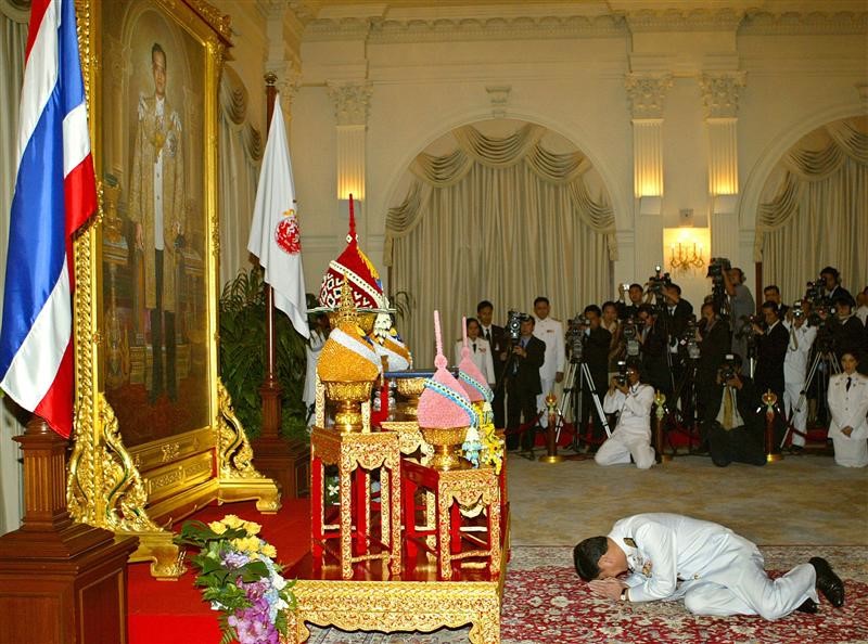 Thủ tướng Thaksin Shinawatra phủ phục trước ảnh chân dung Quốc vương Bhumibol trong buổi lễ nhận sắc phong của Hoàng gia tại Tòa nhà Chính phủ Thái Lan tháng 3/2005, sau khi ông đắc cử thủ tướng. Đây là nghi lễ mà các tân thủ tướng nước này phải thực hiện khi lên nhậm chức. Ảnh: