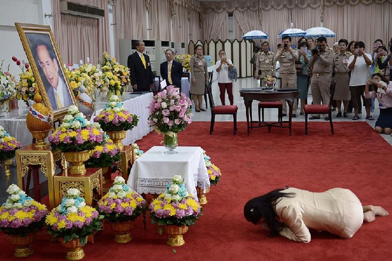 Bà Shinawatra, lúc này không còn tại vị, nằm lạy trước ảnh chân dung Vua Bhumibol khi đến bệnh viện Siriraj, nơi vị vua đang trị bệnh, vào tháng 10/2014. Quốc vương Thái Lan đã được phẫu thuật cắt túi mật. Ảnh: 
