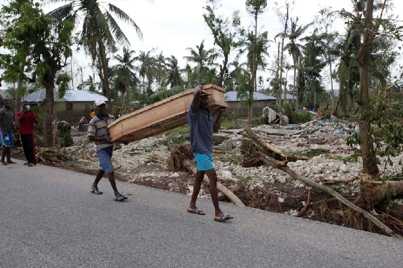 Người dân khiêng quan tài trên đường ở Cavaillon, Haiti sau bão Matthew. Theo Liên Hợp Quốc, bão Matthew đã gây ra cuộc khủng hoảng nhân đạo tồi tệ nhất tại quốc gia Trung Mỹ kể từ sau vụ động đất năm 2010 khiến ít nhất 100.000 người chết.