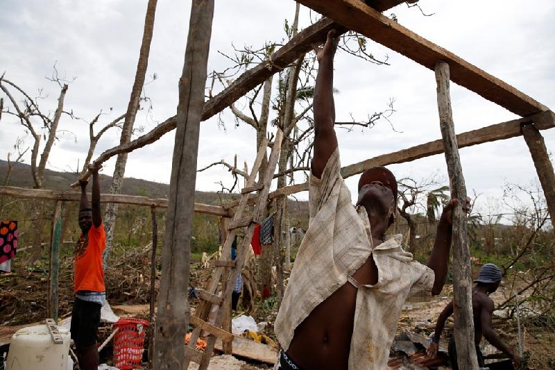 Người dân dựng lại ngôi nhà chỉ còn trơ khung. Bão Matthew đi qua khu vực tây nam Haiti với sức gió khoảng 230 km/h.