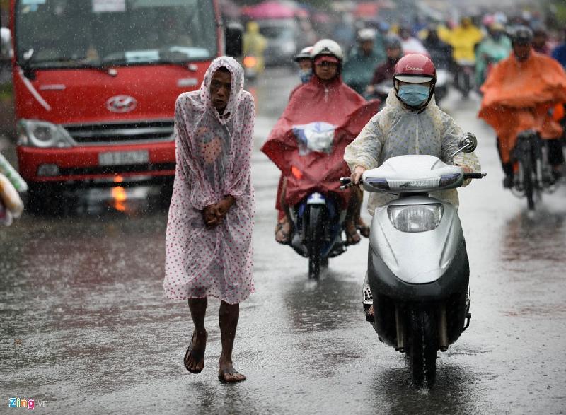 Người đàn ông khúm núm đi giữa trời mưa trên đường Điện Biên Phủ, quận Bình Thạnh.