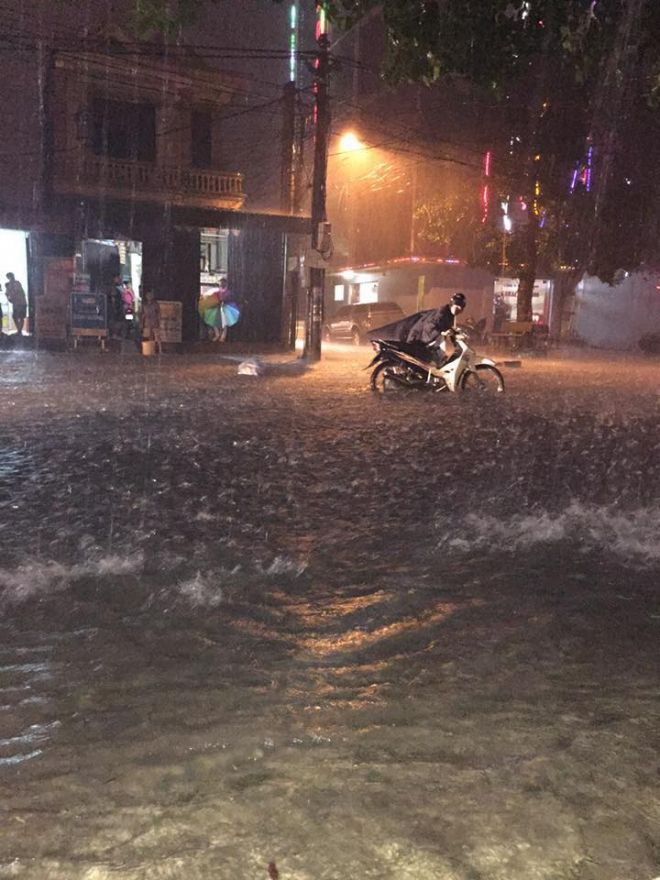 Do mưa lớn, nước chảy xiết nên nhiều người phải dắt xe máy. Những phương tiện giao thông gầm thấp còn mắc kẹt hàng giờ đồng hồ giữa dòng nước, không thể di chuyển được. Ảnh Hoàng Yến