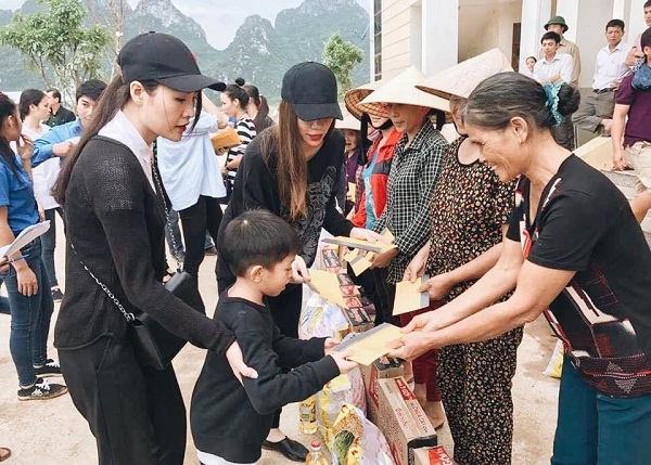 Cậu bé cùng mẹ trực tiếp trao quà cho người dân Quảng Bình. 
