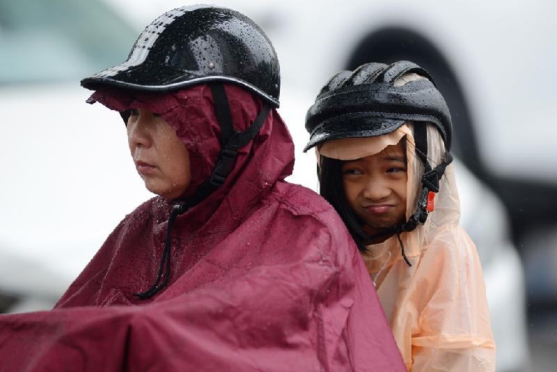 Nhiều người phải mặc áo mưa đi xe máy.