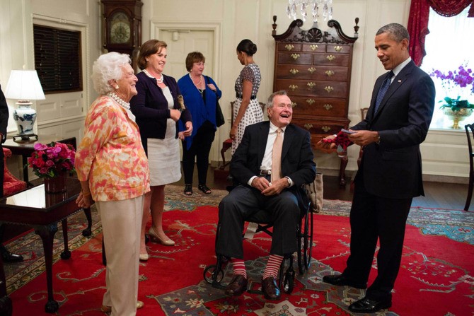 Vợ chồng cựu tổng thống George H. Bush và Barbaba Bush tặng Tổng thống Obama một đôi tất trong Phòng Bản đồ của Nhà Trắng. Cựu tổng thống Bush “cha” là thành viên của đảng Cộng hoà còn ông Obama thuộc đảng Dân chủ nhưng hai gia đình có mối quan hệ rất gắn bó, thân thiết.