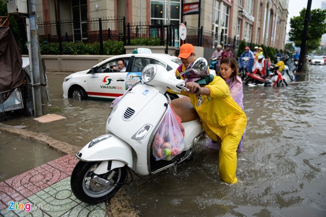 Nhiều người dân chọn biện pháp dắt xe đi trên vỉa hè để vượt qua đoạn ngập nước. 