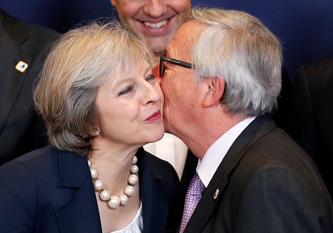Chủ tịch Ủy ban châu Âu Jean-Claude Juncker chào hỏi Thủ tướng Anh Theresa May trong lúc cả hai đang đứng chụp một tấm hình "gia đình" cho hội nghị các lãnh đạo EU diễn ra tại Brussels, Bỉ. Đây là chuyến đi "ra mắt" của bà May đến EU, và một trong những nội dung làm việc của bà tại Brussels là đàm phán việc Anh rời khỏi EU. Ảnh:Reuters.