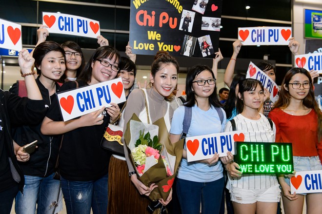 Hàng trăm người hâm mộ có mặt ở sân bay để chào đón Chi Pu. Cô tranh thủ thời gian chụp ảnh bên các bạn trẻ trước khi bước lên ô-tô riêng.