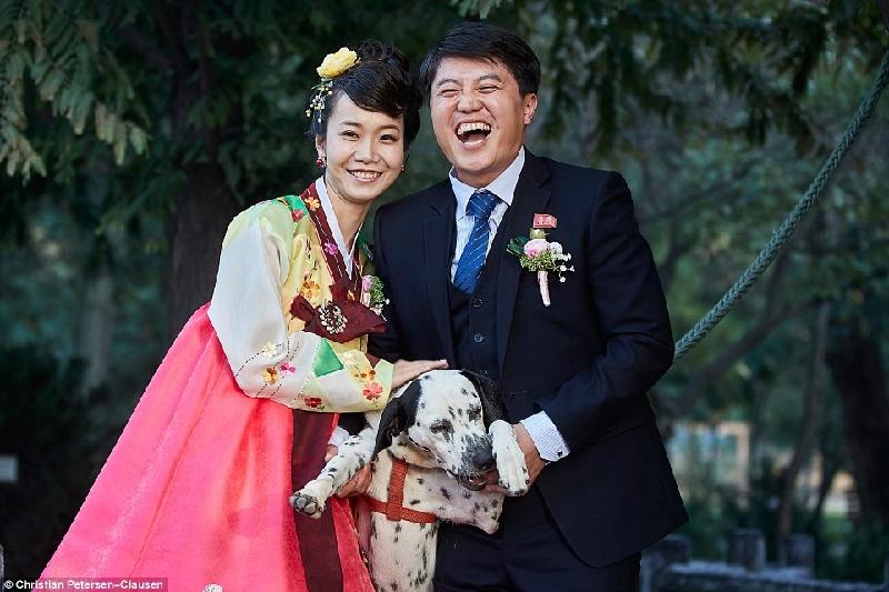Một cặp đôi với chàng trai trong trang phục phương Tây chụp ảnh cùng chú chó cưng.