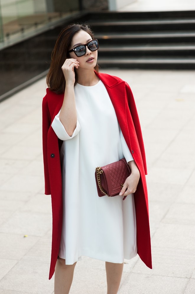Tông màu trắng và đỏ luôn là chọn lựa giúp người mặc nổi bật một cách khéo léo. Trong ảnh, nữ MC diện đầm suông trắng, phối áo măng-tô đỏ. 