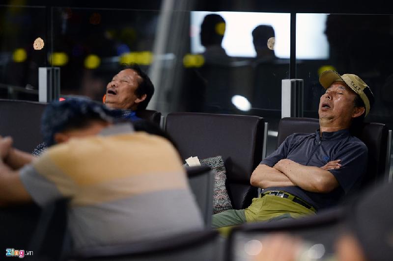 Các vị khách Hàn Quốc ngủ ngồi đợi chờ một chuyến bay cất cánh lúc 0h50 từ Hà Nội tới Busan.