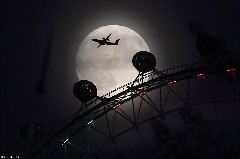 Một phi cơ bay trên nền trời trăng rằm ở thủ đô London của Anh. Ảnh: 