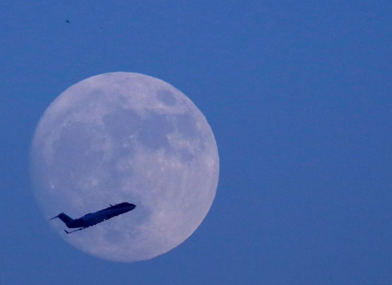 Máy bay bay ngang qua bầu trời Kathmandu ở Nepal, với hậu cảnh mặt trăng. Ảnh: 