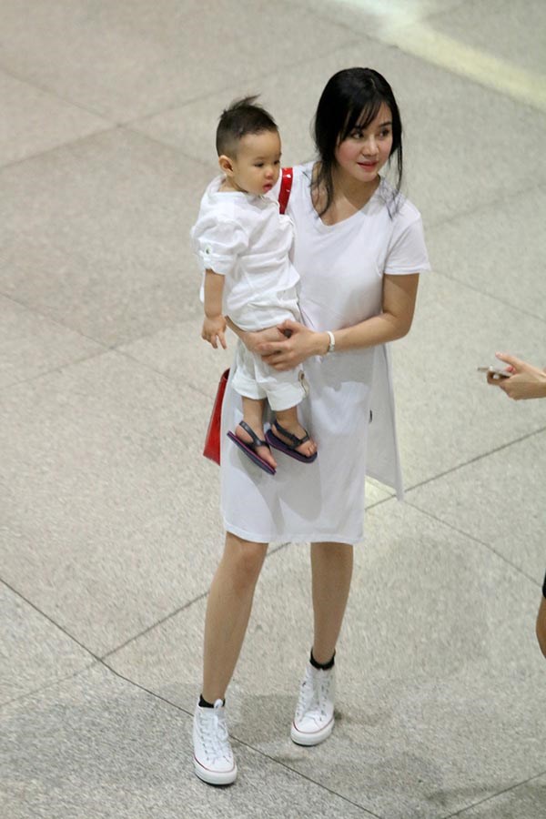 Hai mẹ con Vy Oanh diện cả cây trắng sáng bừng một góc sân bay.