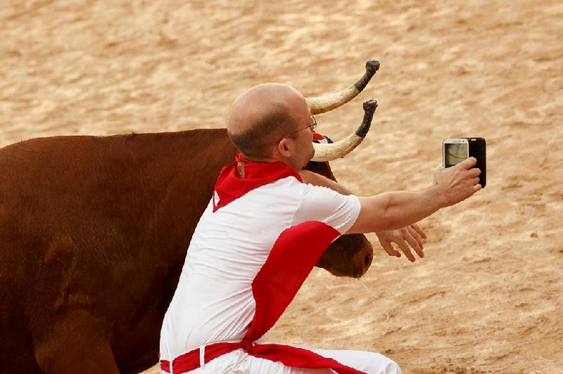 Một người đàn ông liều lĩnh để có tấm hình độc trong lễ hội chạy đua với bò tót được tổ chức vào tháng 7 hàng năm tại thành phố Pamplona, Tây Ban Nha. Đây là một trong những lễ hội nguy hiểm nhất thế giới, khiến 15 người thiệt mạng kể từ năm 1924. Ảnh: