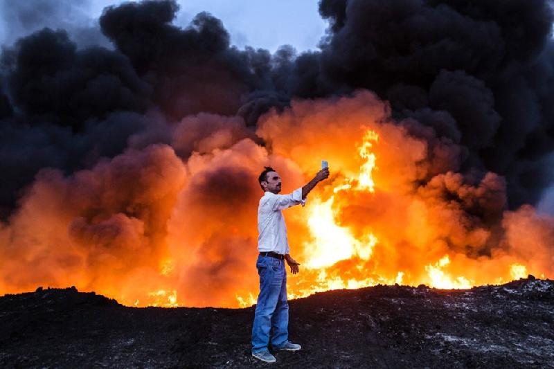 Khoảnh khắc người đàn ông tạo dáng trước đám cháy dầu ở miền bắc Iraq cũng lọt top những bức hình 