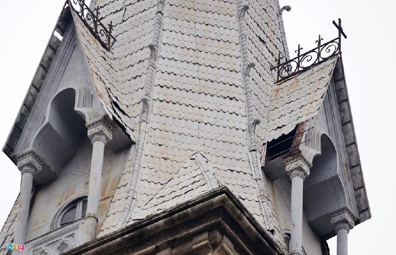 Hai chóp mái tháp chuông bằng tôn kẽm đúc giả ngói màu xám trắng đã bị gỉ, phía dưới, nhiều mảnh tôn bị rơi mất.