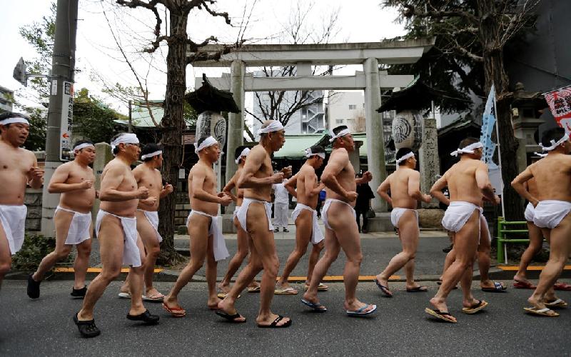 Những người đàn ông mặc khố (tiếng Nhật là "funsoshi") chạy vào sáng sớm nhằm làm ấm cơ thể trước khi tham gia nghi lễ tắm nước đá ở đền Teppozu Inari, Tokyo vào sáng 8/1.