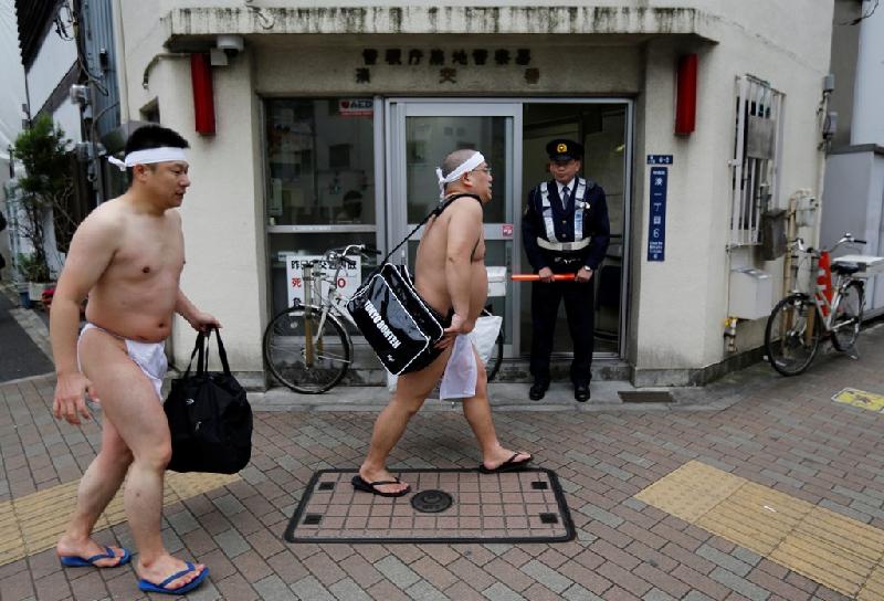 Ảnh chụp hai người đàn ông đi bộ về nhà sau khi kết thúc nghi lễ. Nhật Bản là nơi truyền thống và hiện đại đan xen chặt chẽ vào nhau, tạo nên nhiều điều thú vị trong cuộc sống con người.