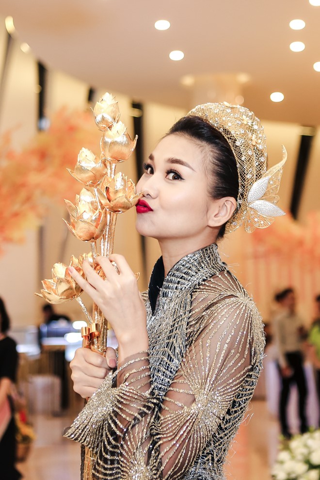 Giám khảo Vietnam's Next Top Model tạo dáng bên bó sen nặng 7 kg được chế tác từ 50 lượng vàng, trị giá hơn 2 tỷ đồng.