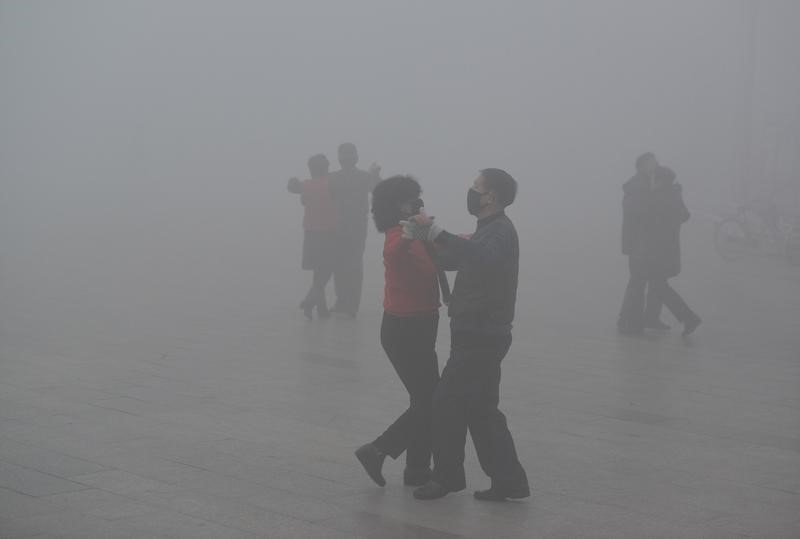 Ngày 1/1, miền bắc Trung Quốc đón năm mới 2017 dưới một đám mây với tỷ lệ hạt bụi độc cao gấp 20 lần mức khuyến cáo của Tổ chức Y tế Thế giới. Tình trạng này có cải thiện sau ngày 1/1 và được dự đoán sẽ khá hơn trong những ngày tới khi Trung Quốc đón một đợt lạnh. Trong ảnh, người dân khiêu vũ trong khói mù tại một quảng trường ở thành phố Phụ Dương (tỉnh An Huy) hôm 3/1. Ảnh: Reuters.