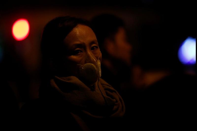 Ở các tỉnh thành miền trung và miền đông, nhiều người cũng trang bị các vật dụng bảo vệ cơ quan hô hấp. Một người phụ nữ đeo khẩu trang ở thành phố Thượng Hải hôm 3/1. Ảnh: Reuters.