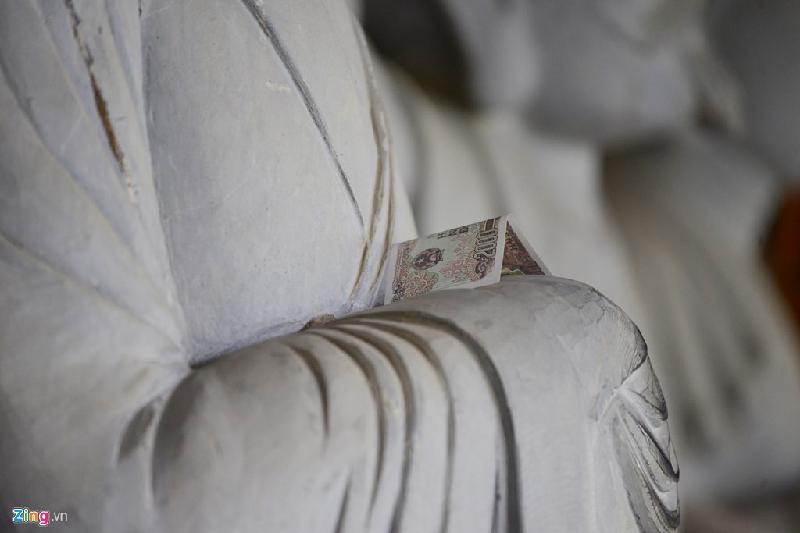 Nhiều người còn nhét tiền lẻ mệnh giá thấp vào các bàn tay tượng. Năm nay, chùa Bái Đính cử hàng chục tình nguyện viên thu dọn tiền lẻ dọc 500 bức tượng, nên hình ảnh phản cảm này có phần bớt đi.