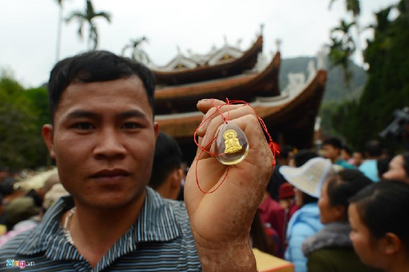 Một người đàn ông may mắn có được lộc may mắn đầu xuân của chùa, một chiếc vòng ngọc đeo cổ mang hình tượng phật vàng.