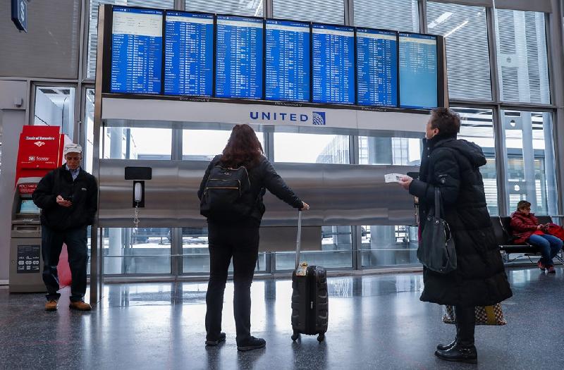 Hành khách theo dõi bảng điện tử về tình trạng các chuyến bay ở sân bay O’Hare. Ảnh: 