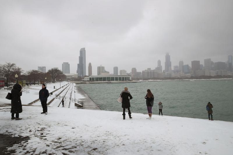 Người dân đi trên con đường ven hồ nước ở trung tâm Chicago ngày 13/3. Thành phố này đã trải qua tháng 1 và tháng 2 không có tuyết, nhưng lượng tuyết rơi từ ngày 14/3 có thể dày đến 12 cm. Ảnh: 