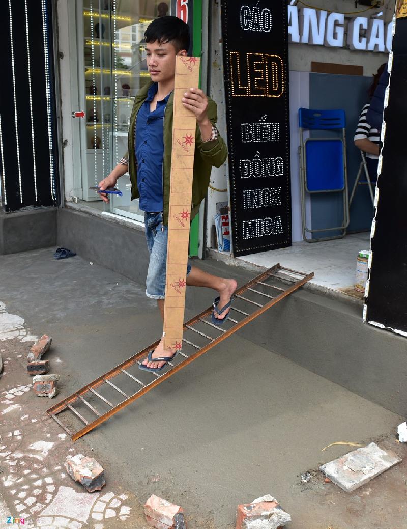 Một cửa hàng kinh doanh ở Ô Chợ Dừa nhanh chóng làm chiếc thang sắt để dắt xe máy lên xuống trong thời gian chờ khô lớp xi măng mới trát.