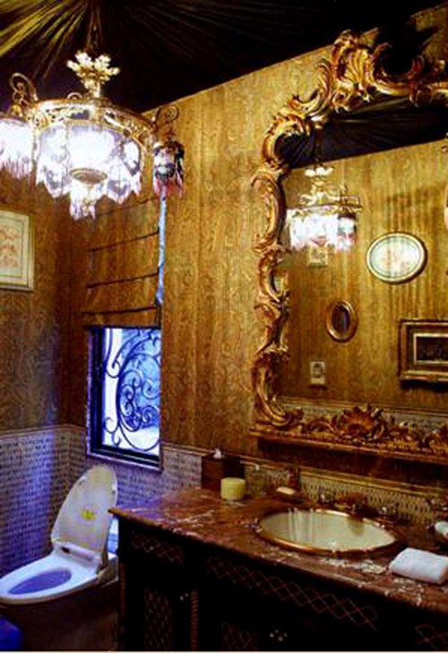 Phòng vệ sinh hào nhoáng, xa hoa với vòi nước sơn vàng rực rỡ có biểu tượng cách điệu của rồng và cá quẫy đuôi.