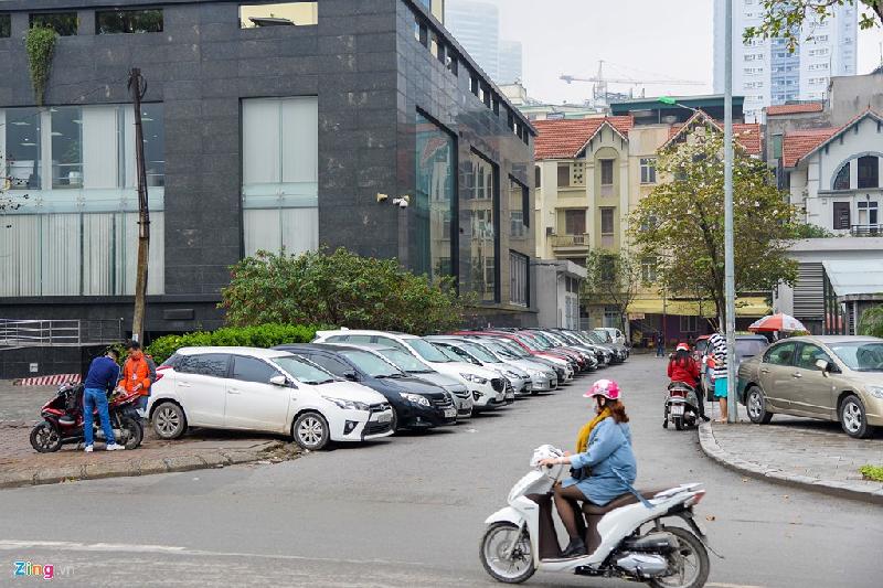 Bên cạnh tòa nhà của Tổng công ty viễn thông Mobifone (Lô VP1, Yên Hoà, Cầu Giấy, Hà Nội) ôtô đỗ đầy vỉa hè lẫn lòng đường sau một tuần ra quân.