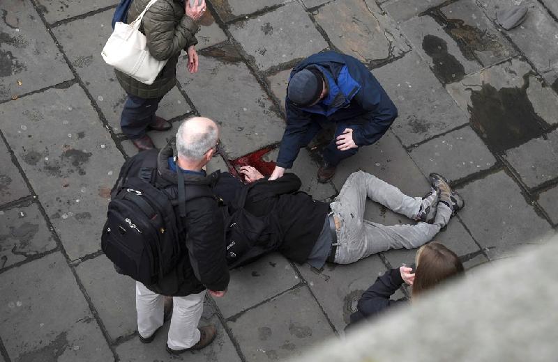 Người bị thương nằm sõng soài tại hiện trường vụ nổ súng. Ít nhất 4 người đang nằm trên mặt đất, một số chảy máu rất nhiều và bất tỉnh trên cầu Westminster gần đó. Ảnh: Reuters. 