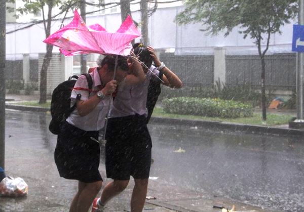 Cơn mưa lớn kèm lốc mạnh đã giật úp chiếc ô khiến hai nữ sinh hoảng hốt tháo chạy