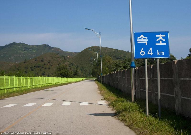 Đường đến khu tổ hợp dành cho khách du lịch được rào hai bên để ngăn người dân xung quanh tiếp cận. Tấm biển trên đường cho thấy thủ đô Seoul, Hàn Quốc cách đó 64 km. 
