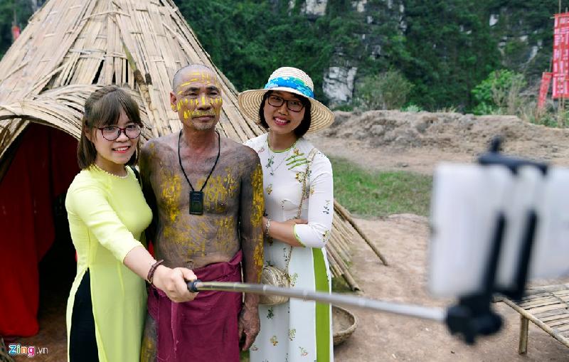 Hạnh, một du khách tham quan đến từ Hà Nội, hào hứng chụp ảnh cùng với thổ dân tại phim trường.