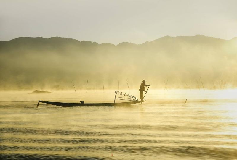 Ngư dân đánh bắt cá khi hơi sương bốc hơi lên từ mặt hồ. Ánh ban mai làm quang cảnh hồ đẹp như bức tranh thủy mặc.