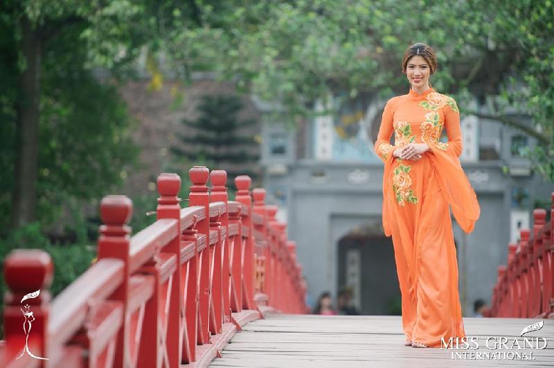 Á hậu 1 Nicole Cordoves nổi bật trong tà áo dài màu cam, kiểu dáng truyền thống. 