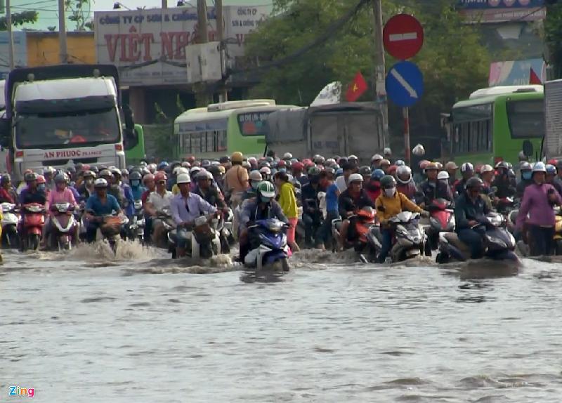 Đoạn gần quốc lộ 1 - Dương Đình Cúc (xã Tân Kiên, huyện Bình Chánh), nước ngập sâu hơn nửa mét khiến nhiều người không dám lưu thông. Một số người cố gắng vượt qua khiến xe cộ chết máy hàng loạt.
