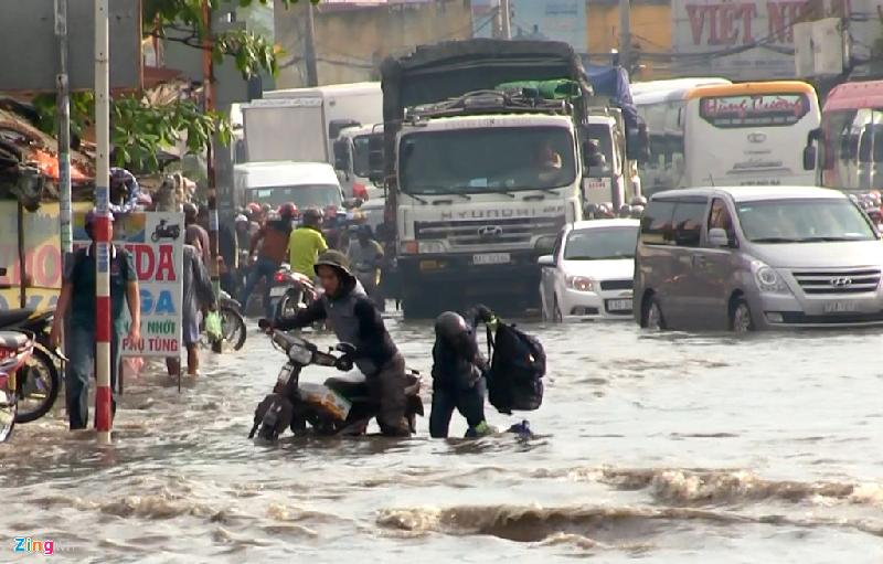 Các ôtô chạy ngang, sóng nước đánh mạnh khiến nhiều xe máy chao đảo té ngã dưới nước. Nhiều đồ đạc, túi xách của người dân bị rơi xuống nước hư hại. 