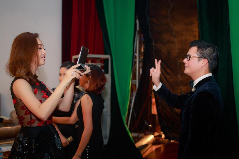 Quang Dũng tạo dáng ở hậu trường sân khấu để Hoa hậu châu Á tại Mỹ chụp ảnh lưu niệm.