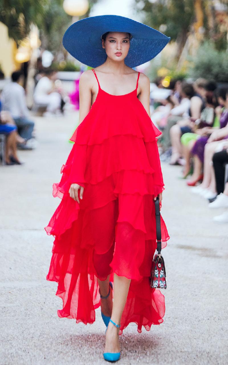 Trình diễn ở show của cựu giám khảo Vietnam's Next Top Model, Chà Mi thể hiện bộ cánh xếp tầng tông màu đỏ. Thiết kế hai dây gợi cảm nhưng phần váy bồng bềnh nữ tính, hợp xu hướng hè. 