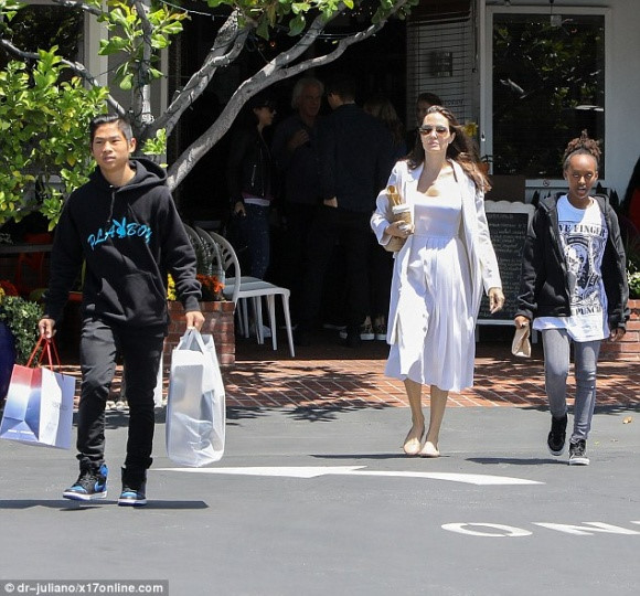 Angelina Jolie cũng bị bắt gặp ra ngoài mua sắm một số đồ cần thiết cùng với hai con là Pax Thiên và Zahara. Anh trai Pax Thiên ra dáng một cậu thanh niên chững chạc khi giúp mẹ và em gái xách đồ. 