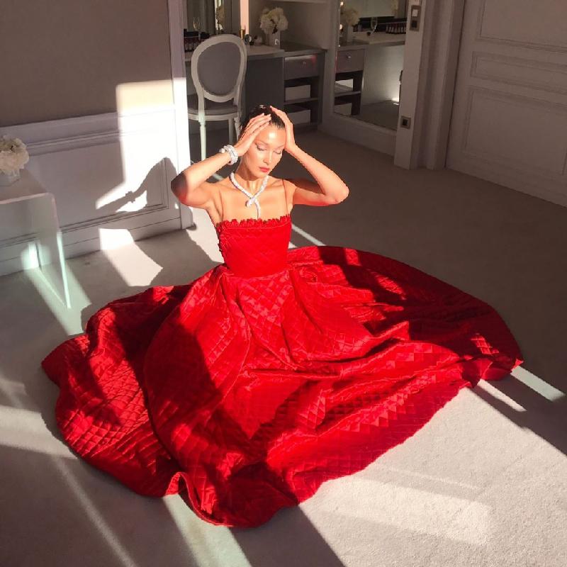 Chiếc váy đỏ rực rỡ hiệu Dior giúp Bella Hadid gây ấn tượng trên thảm đỏ Cannes. Đây là một trong những bộ cánh thảm đỏ kín đáo nhất của Bella. 