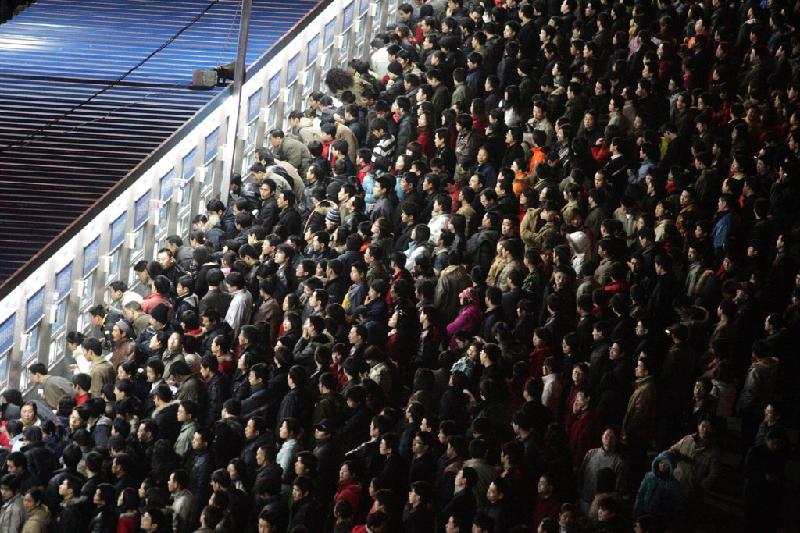 Đám đông du khách Trung Quốc khẩn trương mua vé tàu tại nhà ga ở Bắc Kinh để đi chơi xuân dịp Tết Âm lịch - đợt di chuyển hàng loạt lớn nhất thế giới hàng năm.