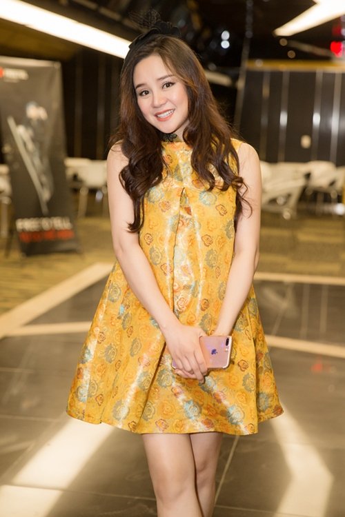 Vy Oanh mặc váy tông vàng rực rỡ, dáng rộng, che bụng bầu tới chúc mừng ca sĩ Bạch Công Khanh ra mắt MV. Nữ ca sĩ tiết lộ đang mang thai ở tháng thứ 8. 