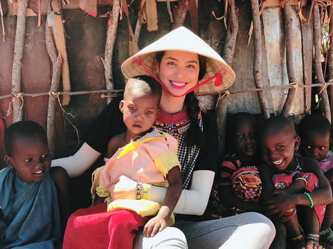 Phạm Hương đeo khăn rằn, thân thiện ẵm bồng trẻ em Kenya